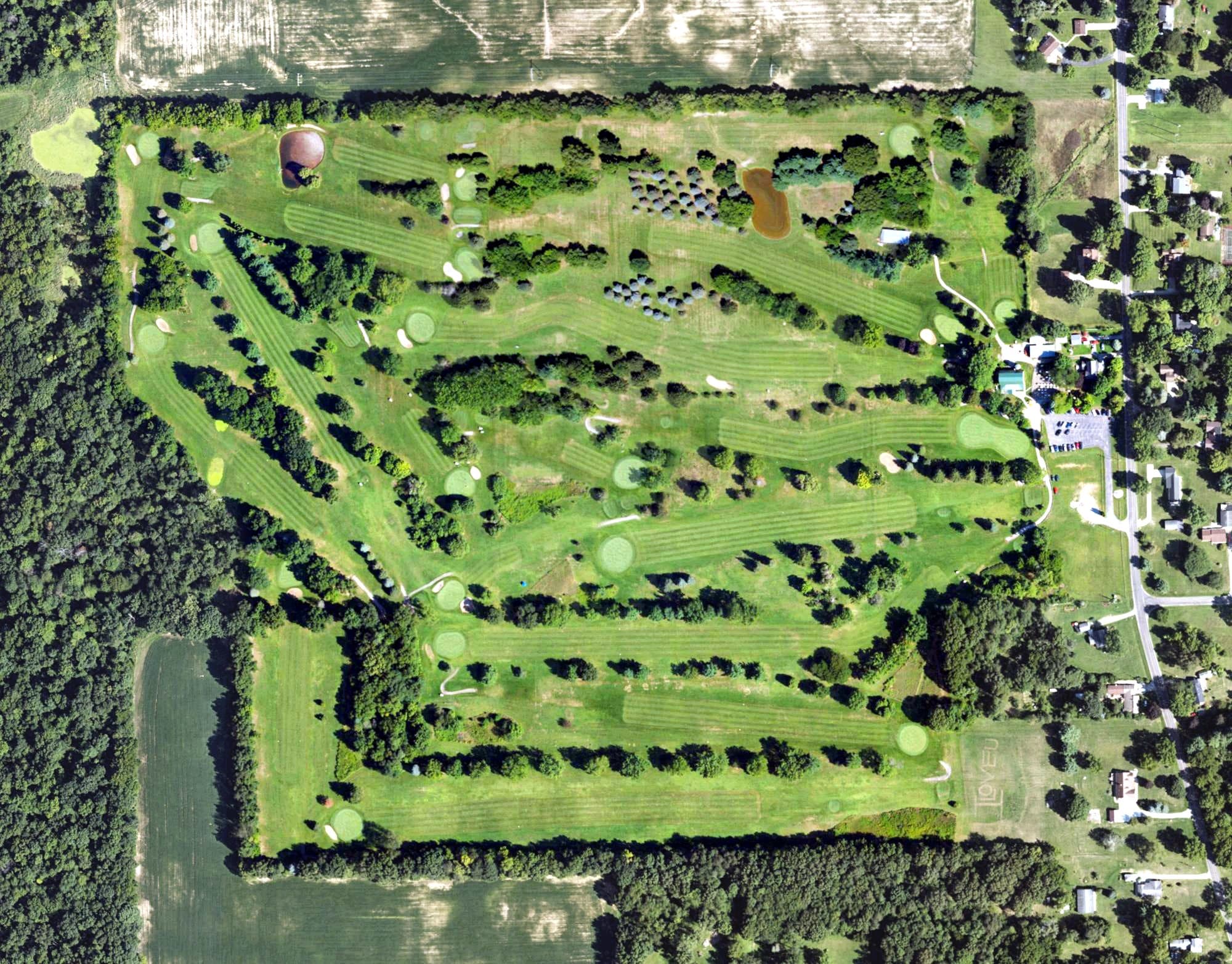 Aerial view of Woodlawn Golf Club, MI, with its hole routing marked